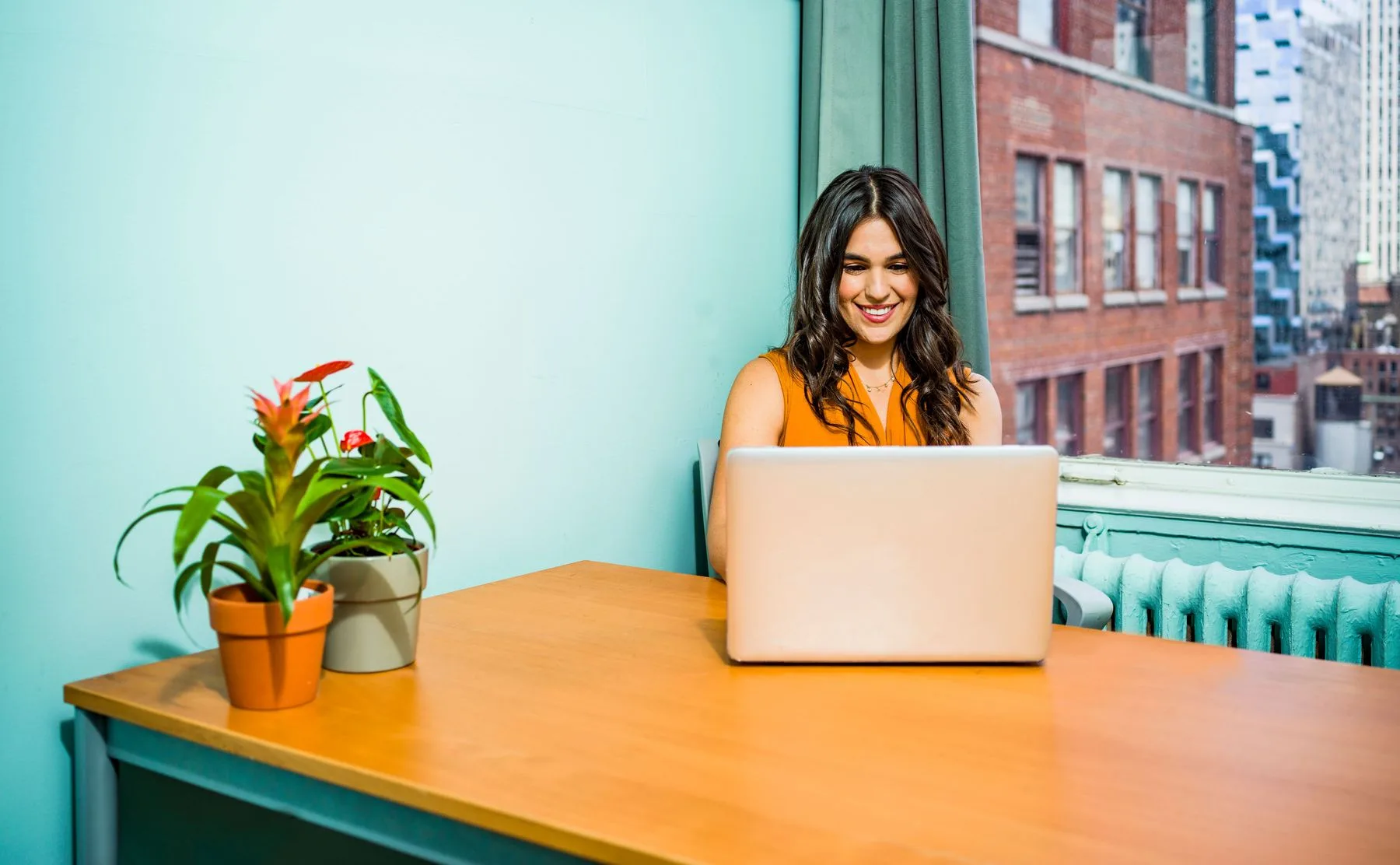 An employee working at her desk beside an office window