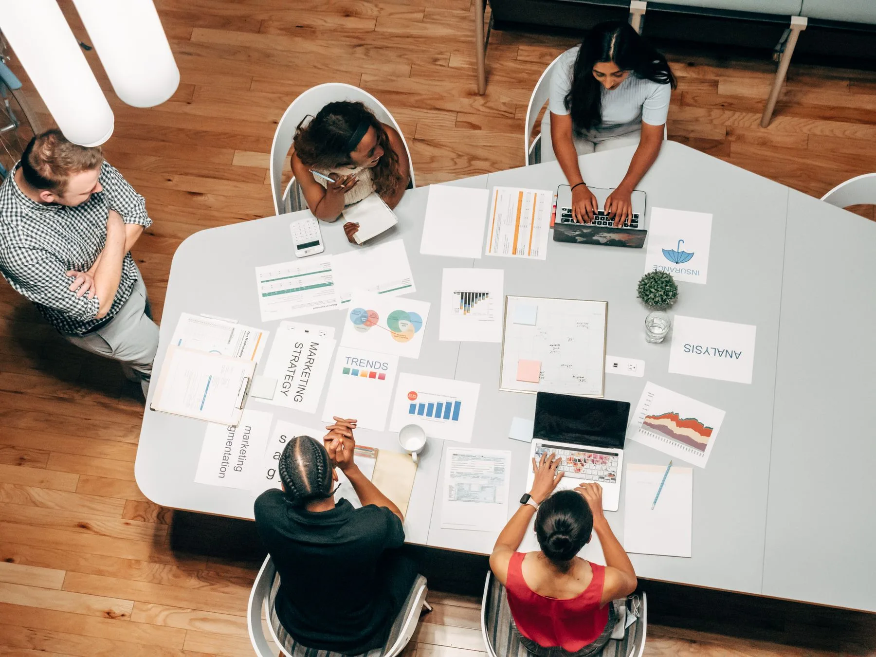 A team working through performance charts, trend reports and figures spread across a table